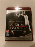 A boxed movie case for 'American Gangster' with Russell Crowe and Denzel Washington, photographed against a plain off-white background. The cover is mostly black and white with red accents, and age rating badges are visible on the lower left.