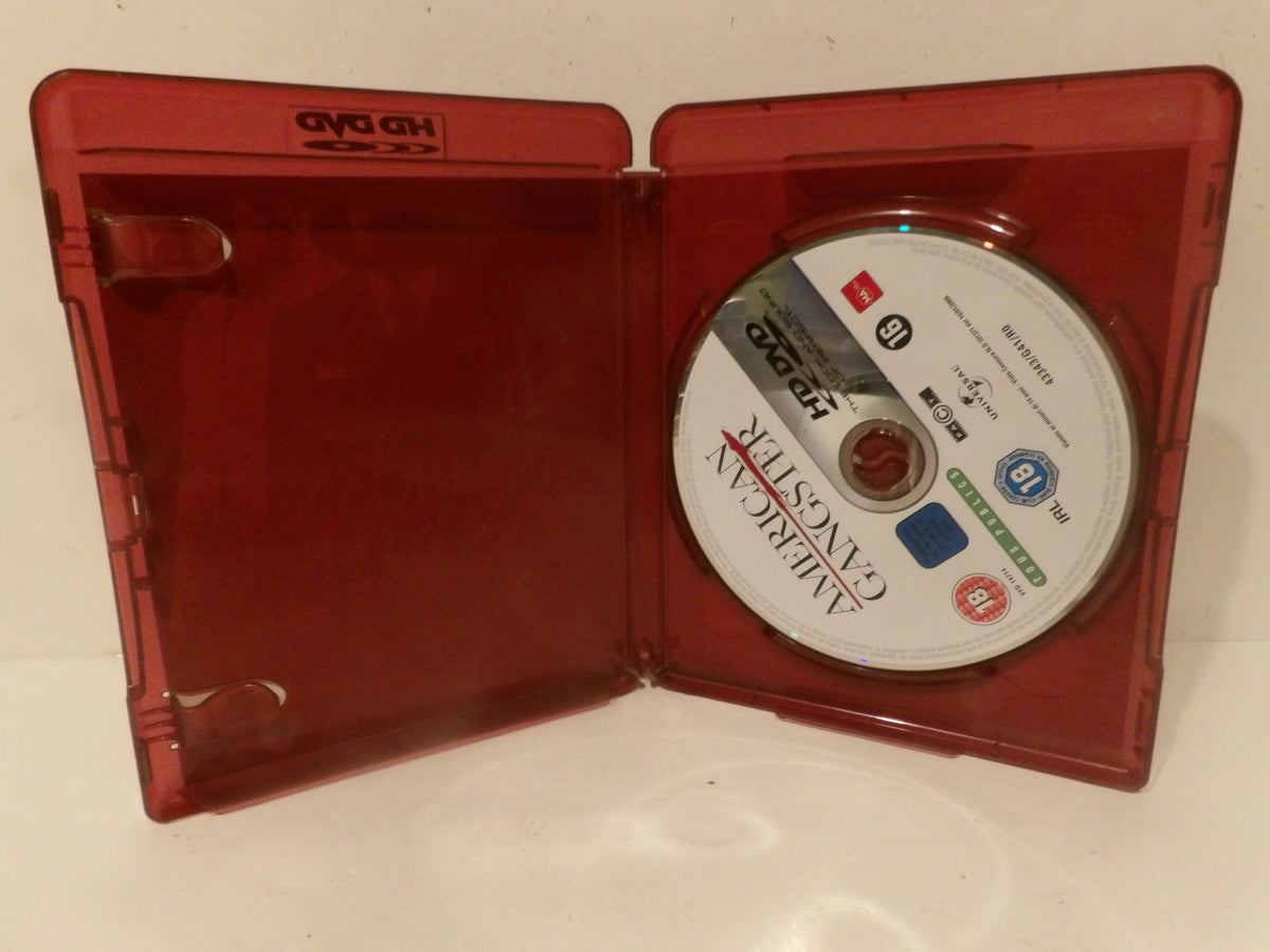 An open translucent red plastic HD DVD case containing a disc of the movie 'American Gangster', photographed on a white surface.