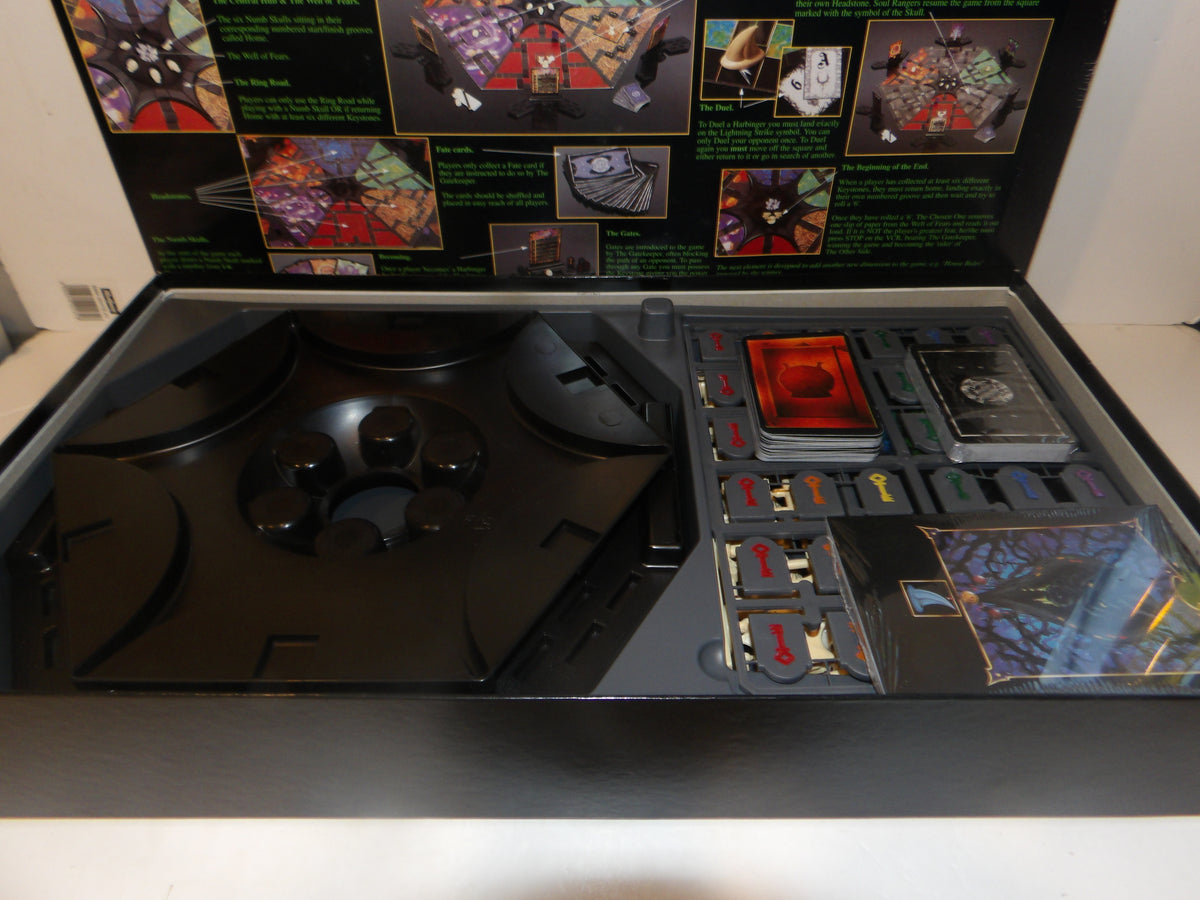 Open Magic: The Gathering game box showing the black playmat, game components, cards, and a printed illustrated insert panel inside the lid.