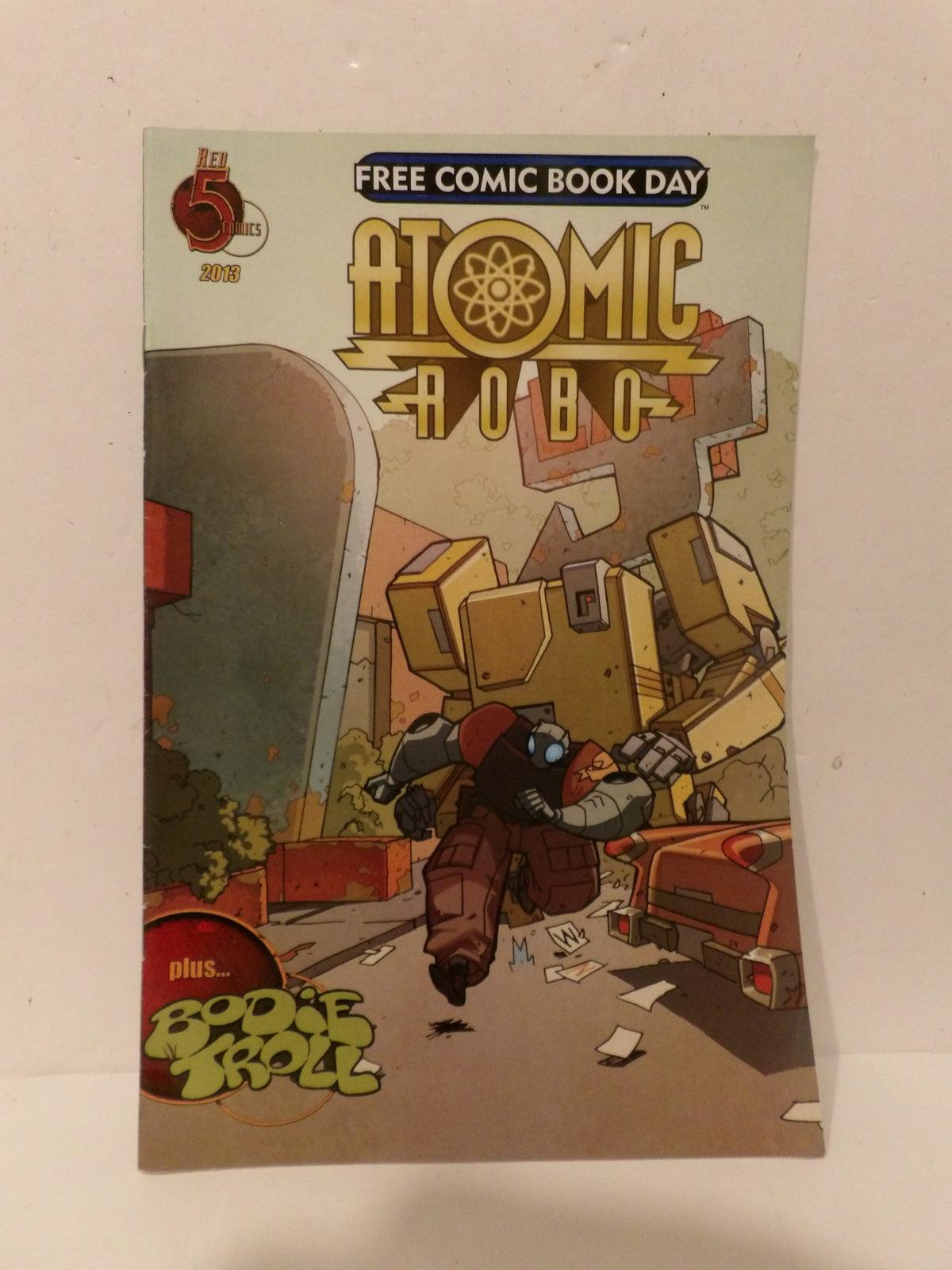 A comic book titled 'Atomic Bobo' with 'Free Comic Book Day' text at the top, photographed standing against a plain light background.