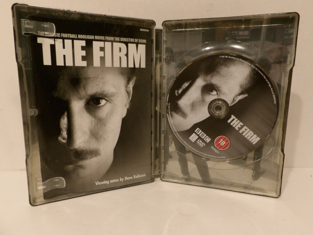 The Firm 4K DVD movie case shown open, with the front cover on the left and the DVD disc on the right, photographed on a light surface.