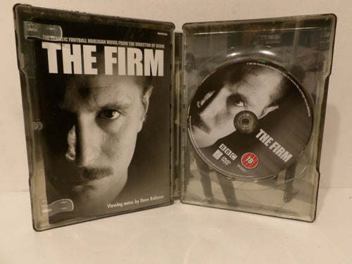 The Firm 4K DVD movie case shown open, with the front cover on the left and the DVD disc on the right, photographed on a light surface.