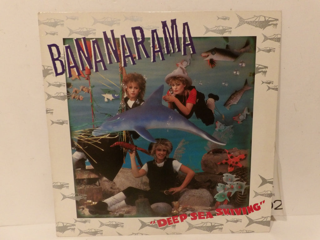 Bananarama 'Deep Sea Skating' vinyl record sleeve, showing a colorful underwater scene with children and a dolphin on the cover, photographed standing against a white background.