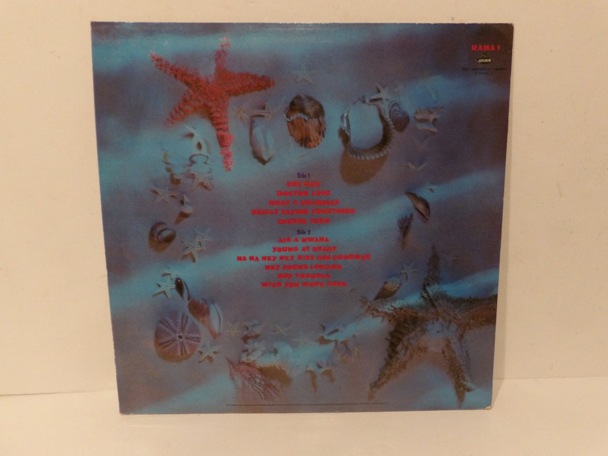 The back cover of a Magma 1 vinyl record album featuring an underwater scene with starfish, shells, and red text on a blue and teal background, photographed standing against a plain off-white wall.