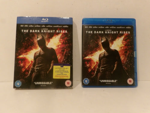 Two Blu-ray copies of The Dark Knight Rises, one in a standard blue plastic case and one in a larger 4K Ultra HD case, displayed side-by-side on a white surface.