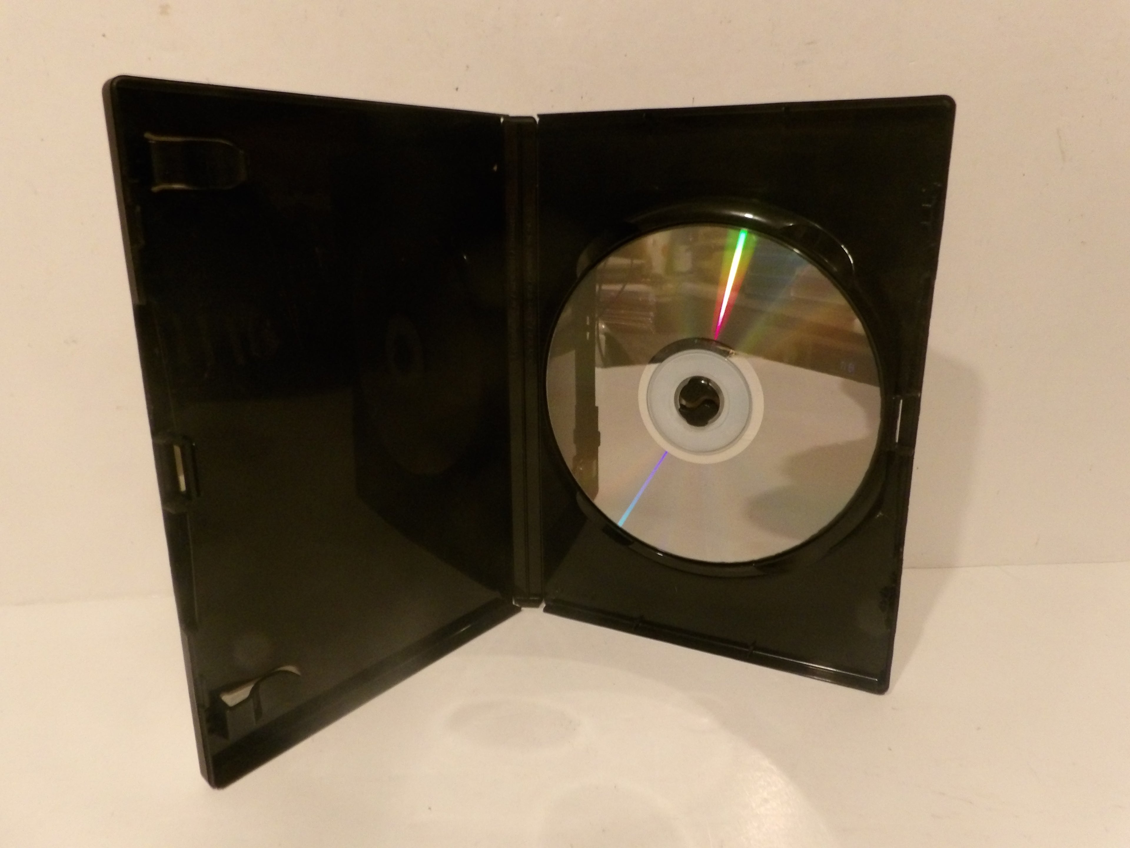 An open black plastic DVD case holding a silver reflective DVD disc, photographed against a plain off-white background.