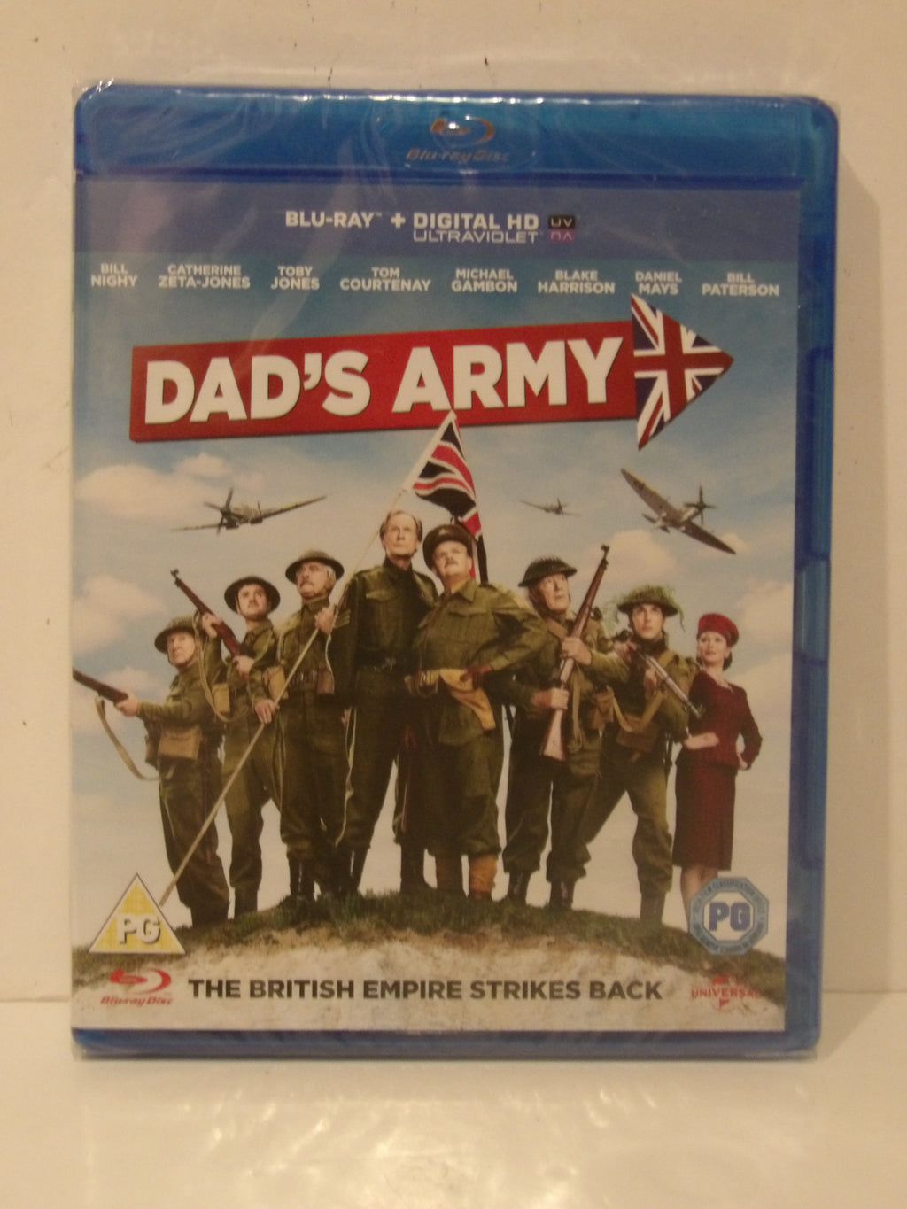 A Blu-ray case for the movie 'Dad's Army' photographed against a plain light background. The case is wrapped in protective plastic and shows the front cover artwork with the title in large red letters, a Union Jack arrow, military uniforms, planes, and a Blu-ray logo at the bottom.