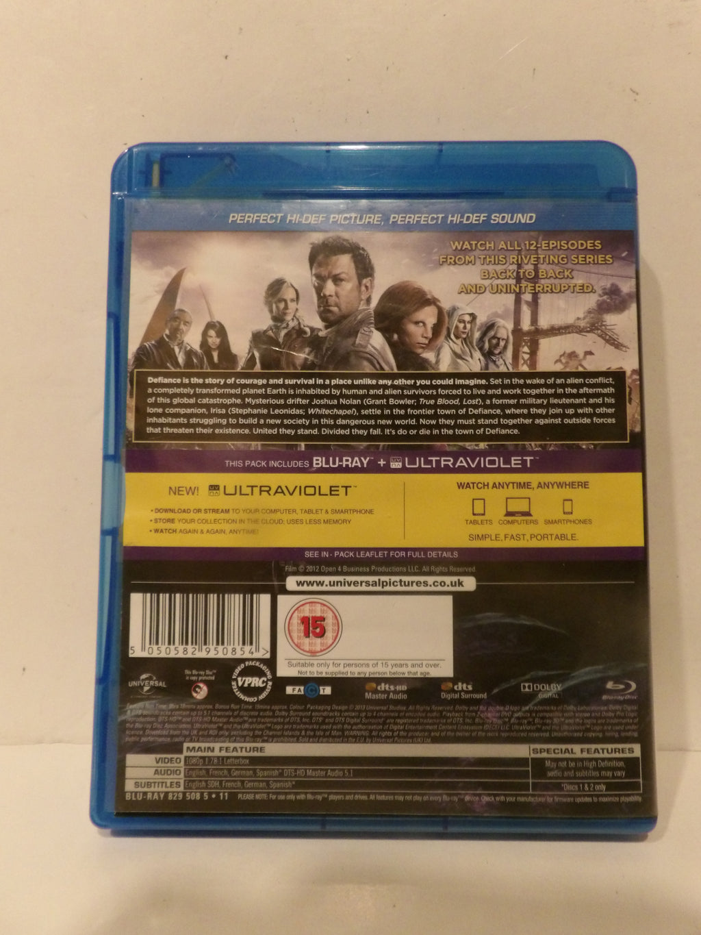 Back cover of a Blu-ray movie case for 'The Crown' on a light beige surface. The case is blue plastic with a black and yellow back panel featuring character artwork, product details, a barcode, and the Universal Pictures logo.