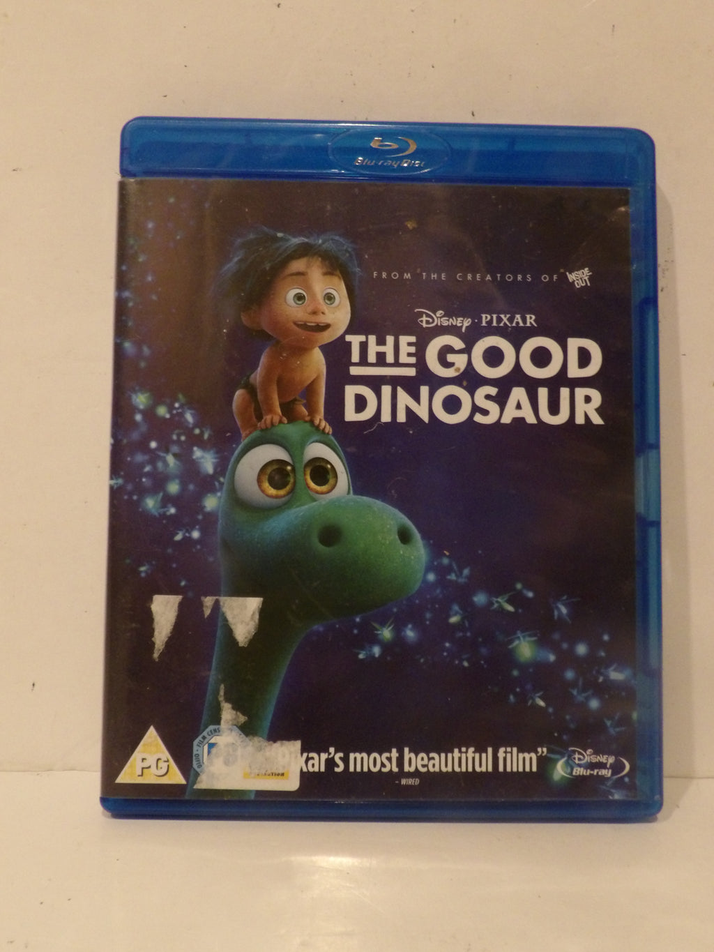 Disney Pixar The Good Dinosaur Blu-ray case on a light beige surface, showing the front cover with Arto the green dinosaur and the title in white text.