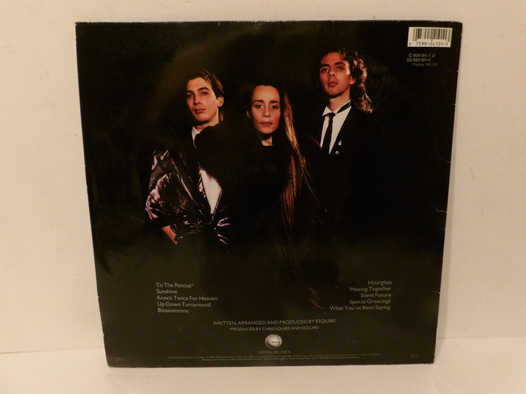 The back cover of a vinyl record sleeve for the band Whistleblanded, featuring a black background with a printed color photograph of the three band members and track listing text.