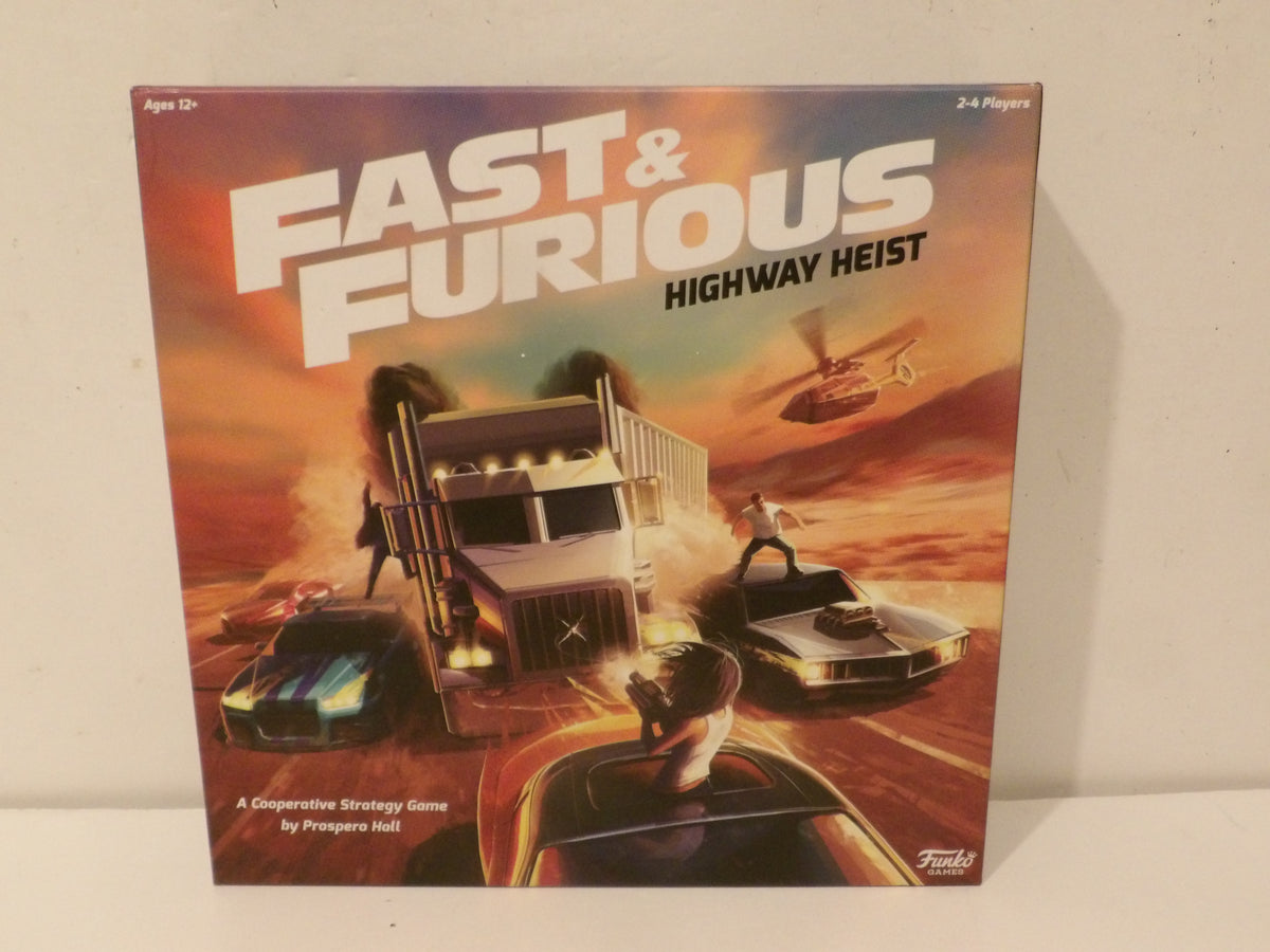 Fast & Furious: Highway Heist board game box on a light beige wall background. The box art features a dramatic desert chase scene with a semi-truck, cars, a helicopter, and the bold white title 'FAST & FURIOUS' at the top.