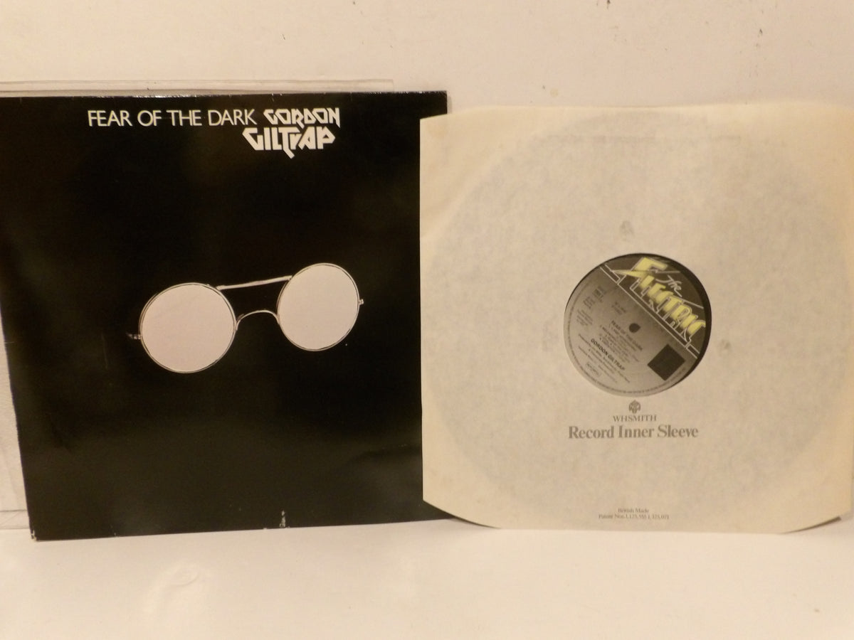 A black vinyl record sleeve for 'Fear of the Dark' by 'Surreal Cult Tap' shown next to its off-white paper record inner sleeve on a white surface.