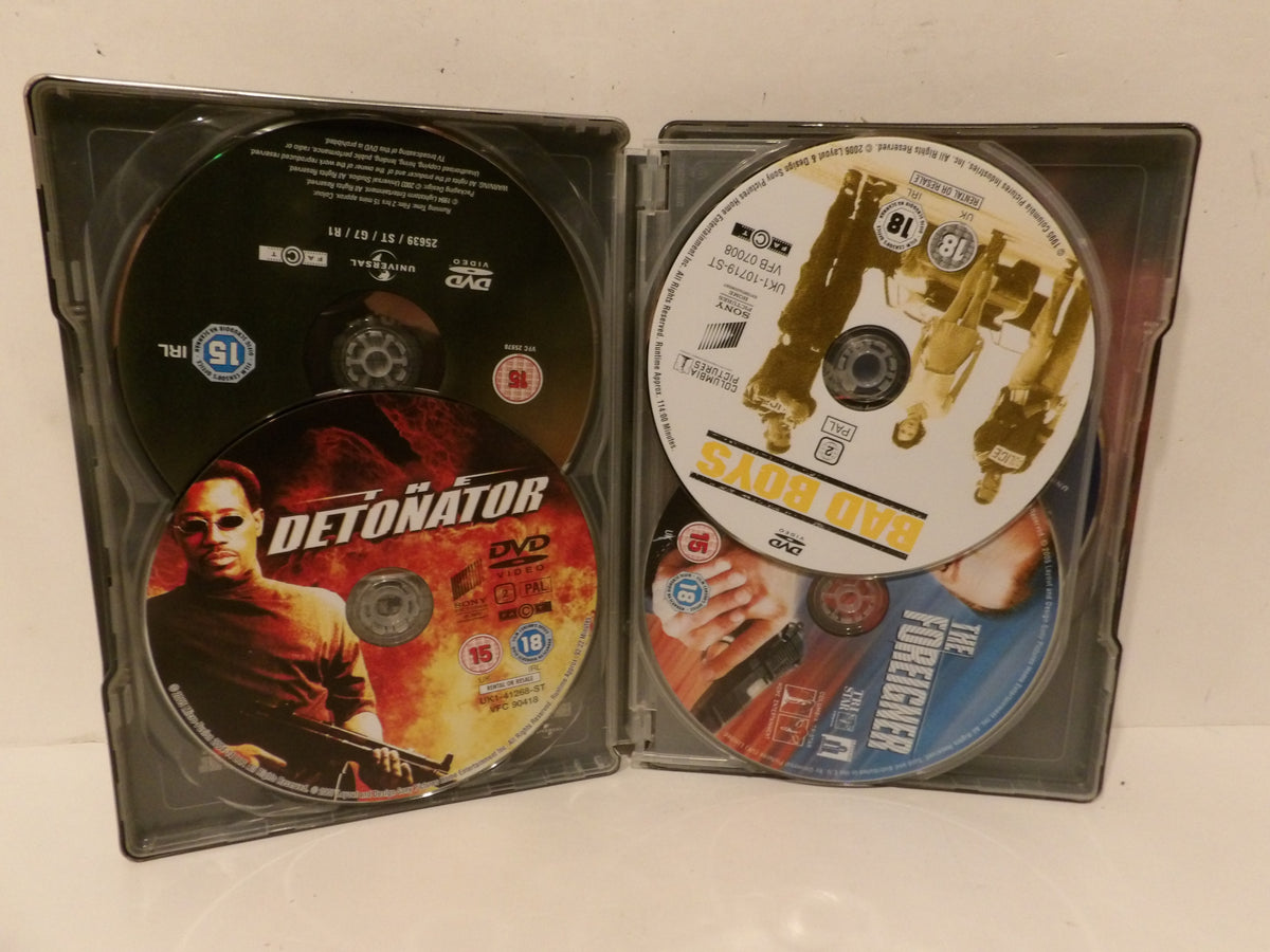 A black plastic DVD case opened flat, showing multiple discs from the movie 'Detonator'. The left side contains a black disc and a red/orange cover disc with the 'Detonator' title and actor images.