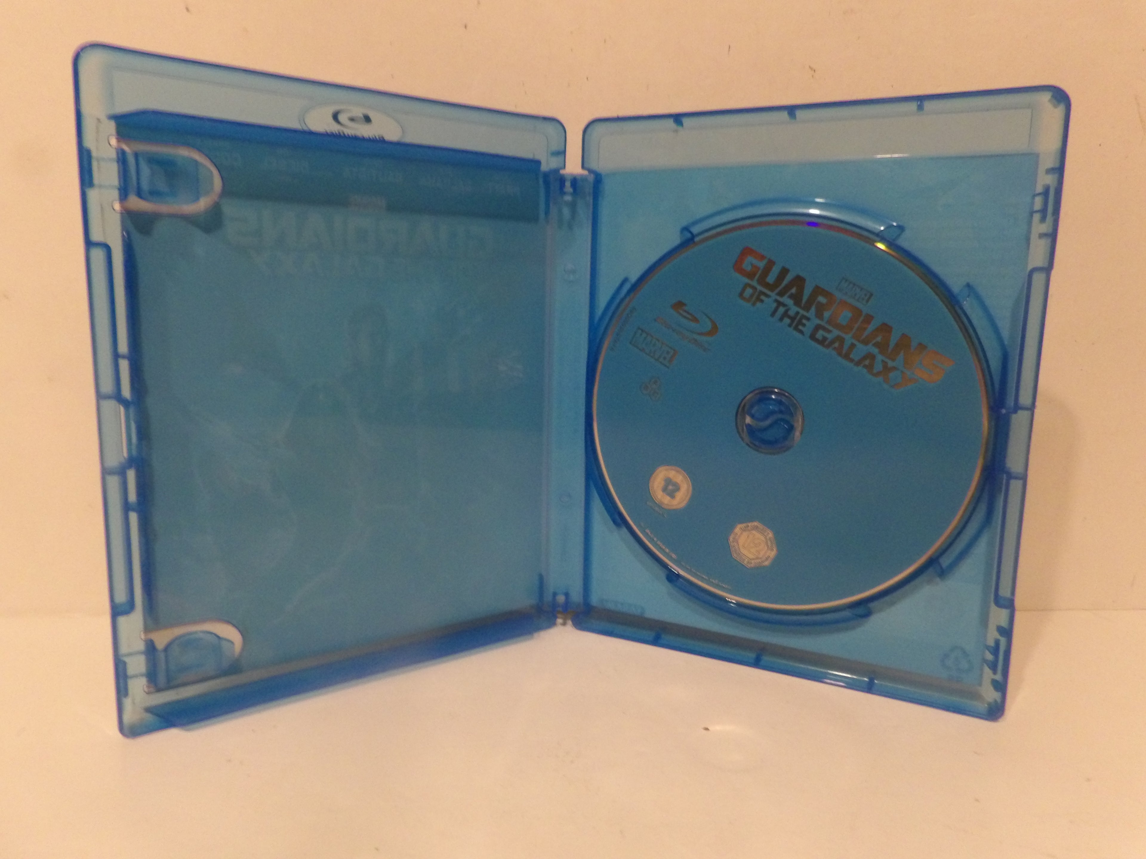 An open translucent blue Blu-ray case containing a blue disc for Guardians of the Galaxy, photographed against a plain light background.