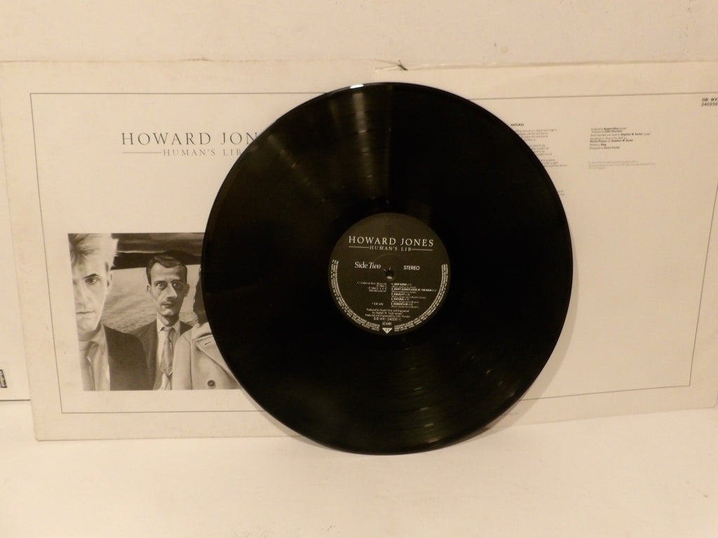 A black vinyl record for Howard Jones's 'Side Steer' leaning against its white paper sleeve, which features a black-and-white portrait of the artist.