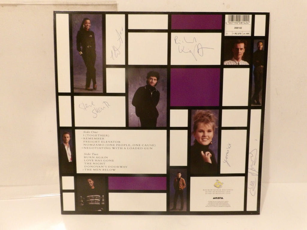 An autographed 12-inch vinyl record LP cover for Eric Clapton's 'Remember', displayed on a white surface. The cover features a black and white geometric grid design with purple accent blocks, containing photos of Eric Clapton, song lyrics, and multiple handwritten autographs.
