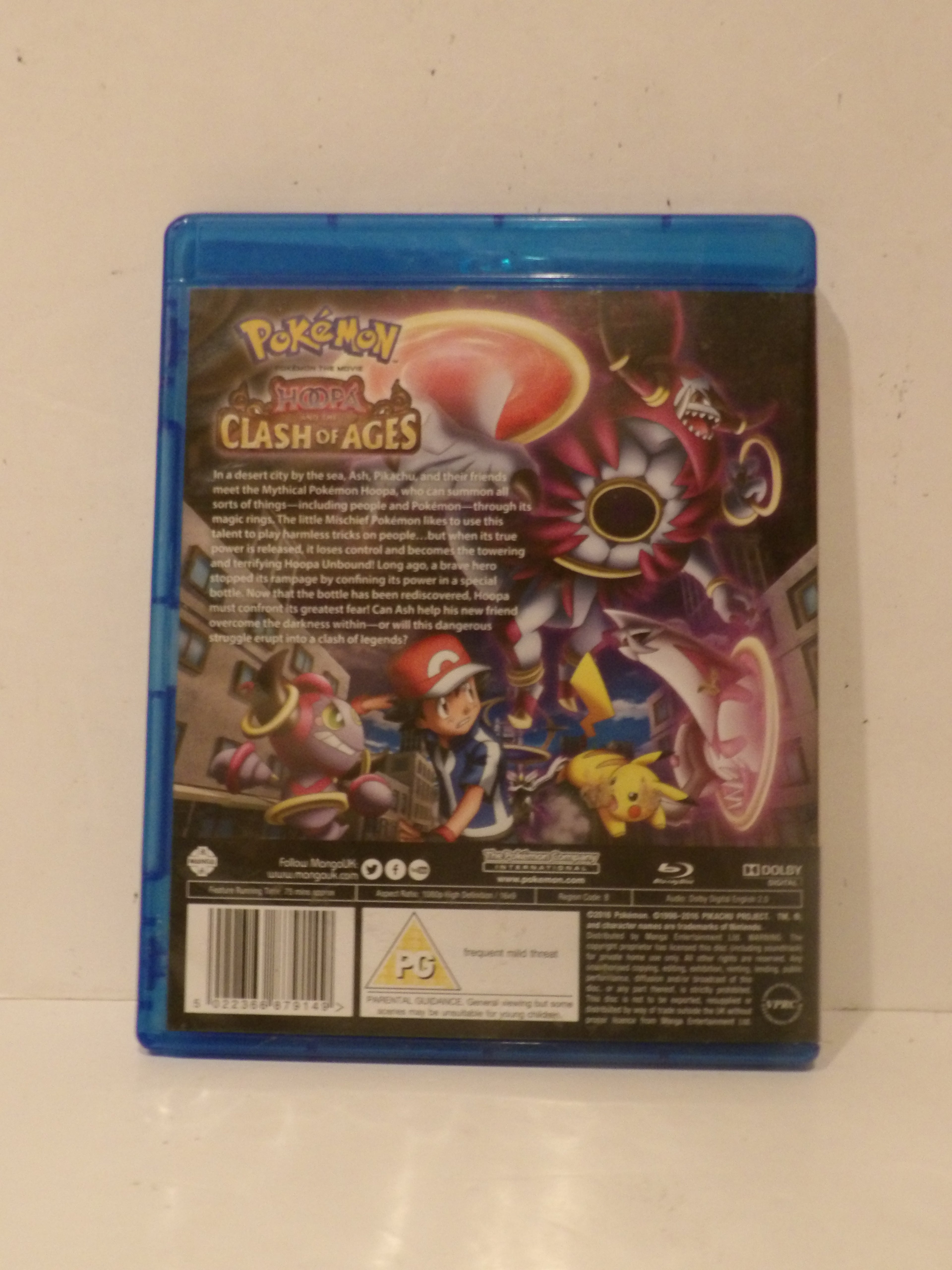 The back cover of a Pokémon: Mirror, and Clash of Ages video game on Blu-ray, shown in its blue plastic case against a plain off-white background.