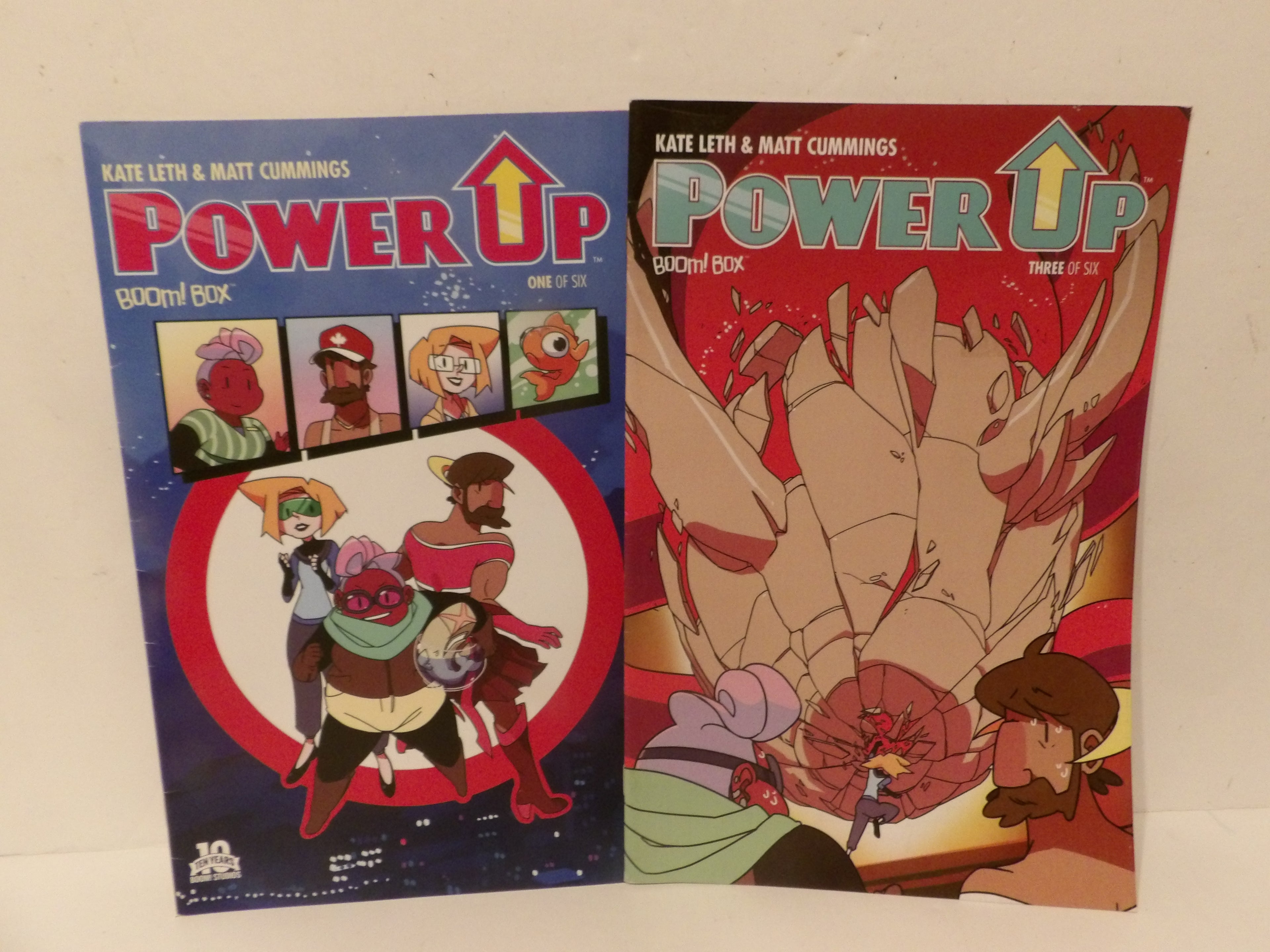 Two comic book boxes for the Power-Up comic series, showing the front and back covers side-by-side against a plain light background.