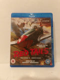 A Blu-ray case for the movie 'Red Tails' standing upright against a plain off-white background. The cover art features a red and gray fighter plane in flight with dramatic explosions, and the title 'RED TAILS' is printed in large red letters.