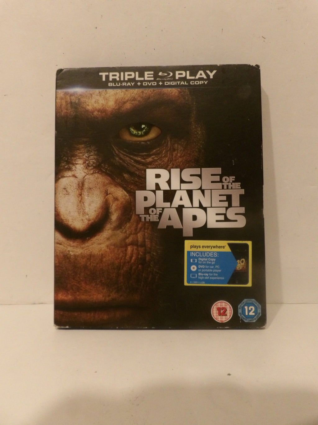 Rise of the Planet of the Apes Triple Play Blu-ray, DVD, and Digital Copy case, featuring a close-up of a great ape's face on the cover with a yellow and blue PETA logo on the front.