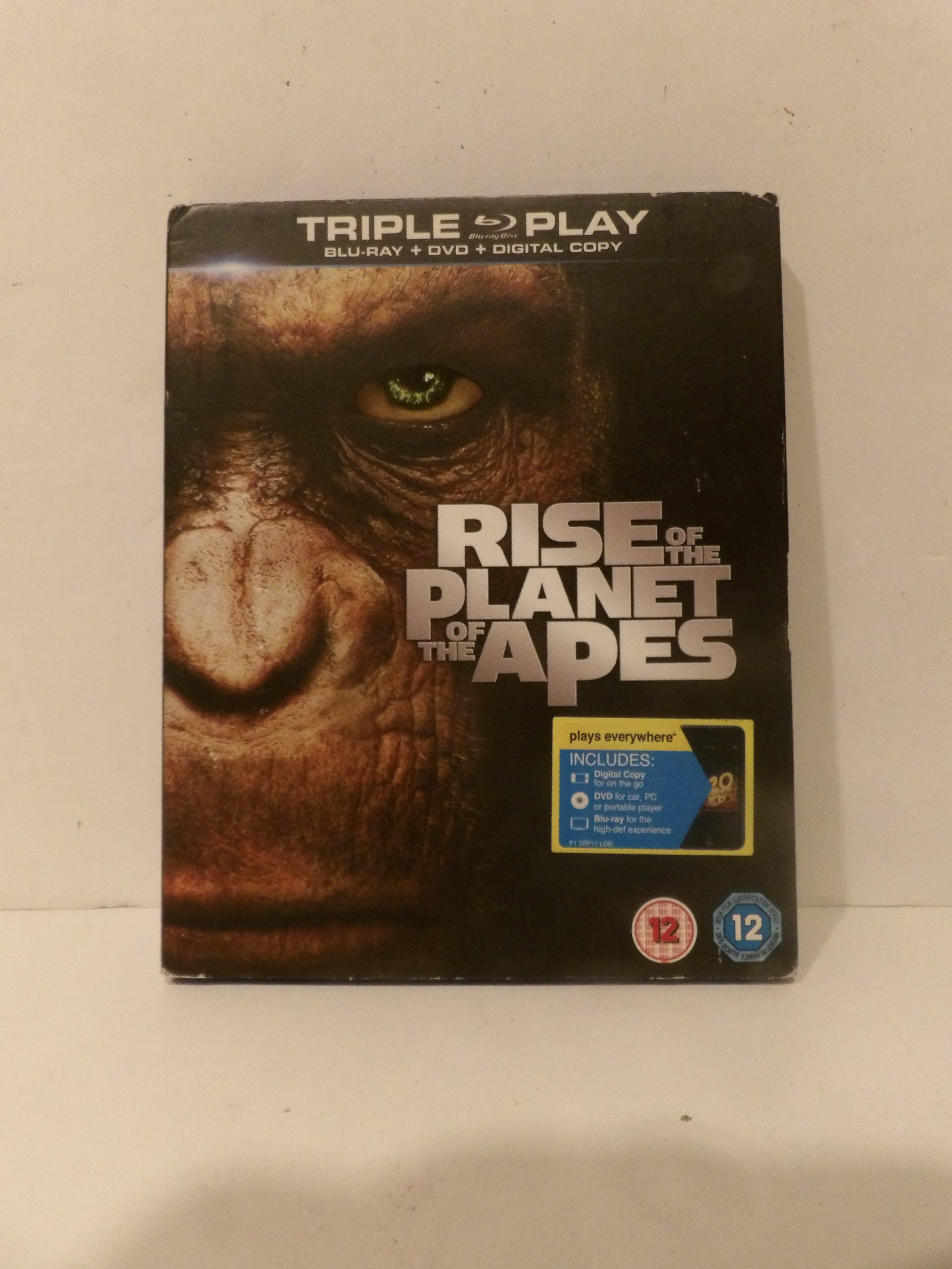 Rise of the Planet of the Apes Triple Play Blu-ray, DVD, and Digital Copy case, featuring a close-up of a great ape's face on the cover with a yellow and blue PETA logo on the front.