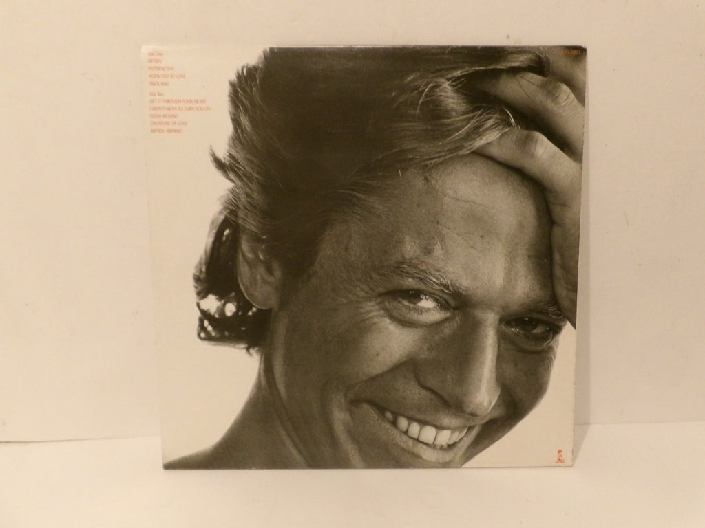 A square album cover featuring a black-and-white close-up portrait of a smiling man with his hand on his hair, photographed against a plain off-white background.