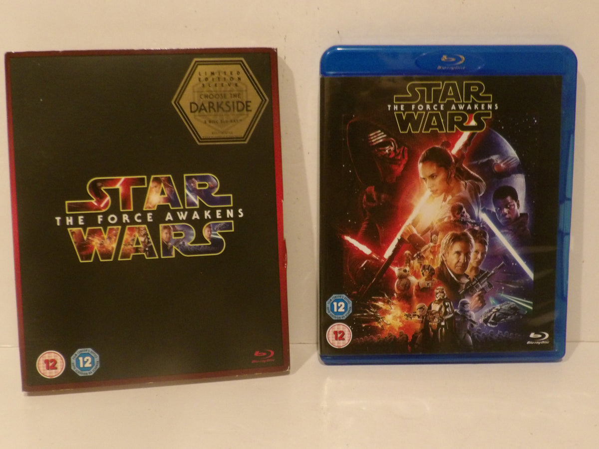 Star Wars: The Force Awakens Blu-ray case next to its black slipcover with a gold Darkside emblem, on a white surface.