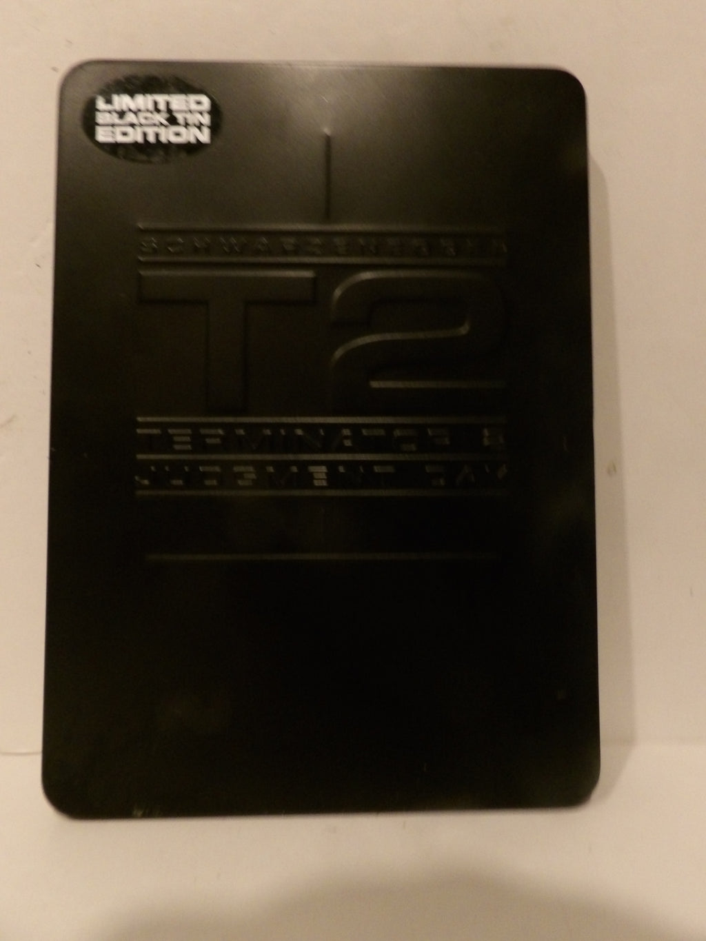 A black limited edition collectible plaque or cover for 'T2: Swatwheels', featuring embossed lettering and a small 'Limited Edition' sticker in the top left corner.