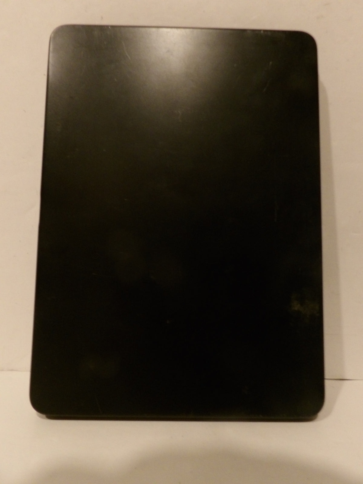 A black rectangular tablet or e-reader cover with rounded corners, shown from the back against a plain off-white background.