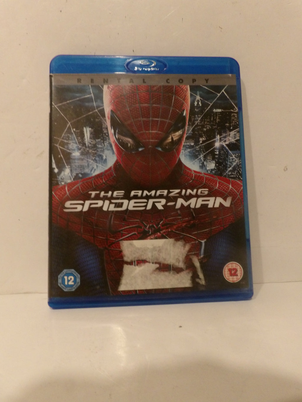 A Blu-ray case of The Amazing Spider-Man 1, featuring Spider-Man on the cover with a blue plastic case border, photographed on a light-colored surface.