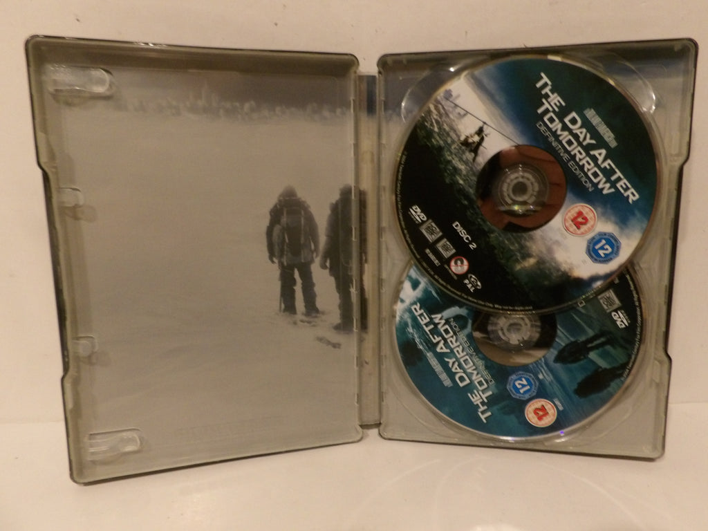 Open DVD case for the movie 'The Day After Tomorrow' showing the printed cover art on the left tray and two discs on the right, photographed on a plain light background.