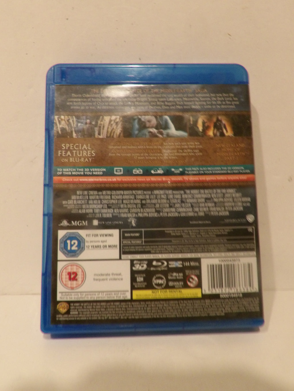 The back cover of a Blu-ray movie case, showing the blue plastic case edge, barcode, age rating, and technical feature labels on a plain off-white background.