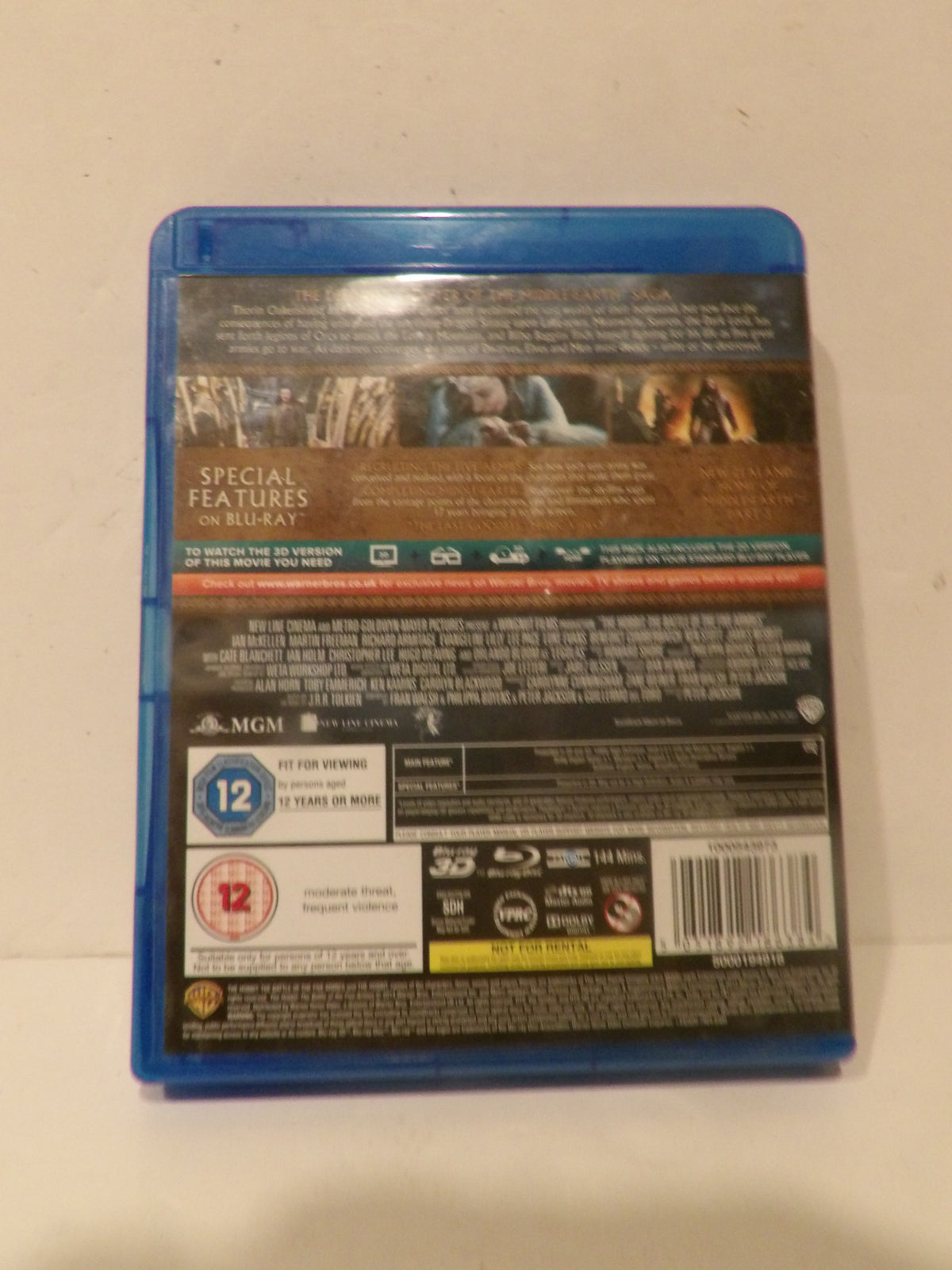 The back cover of a Blu-ray movie case, showing the blue plastic case edge, barcode, age rating, and technical feature labels on a plain off-white background.