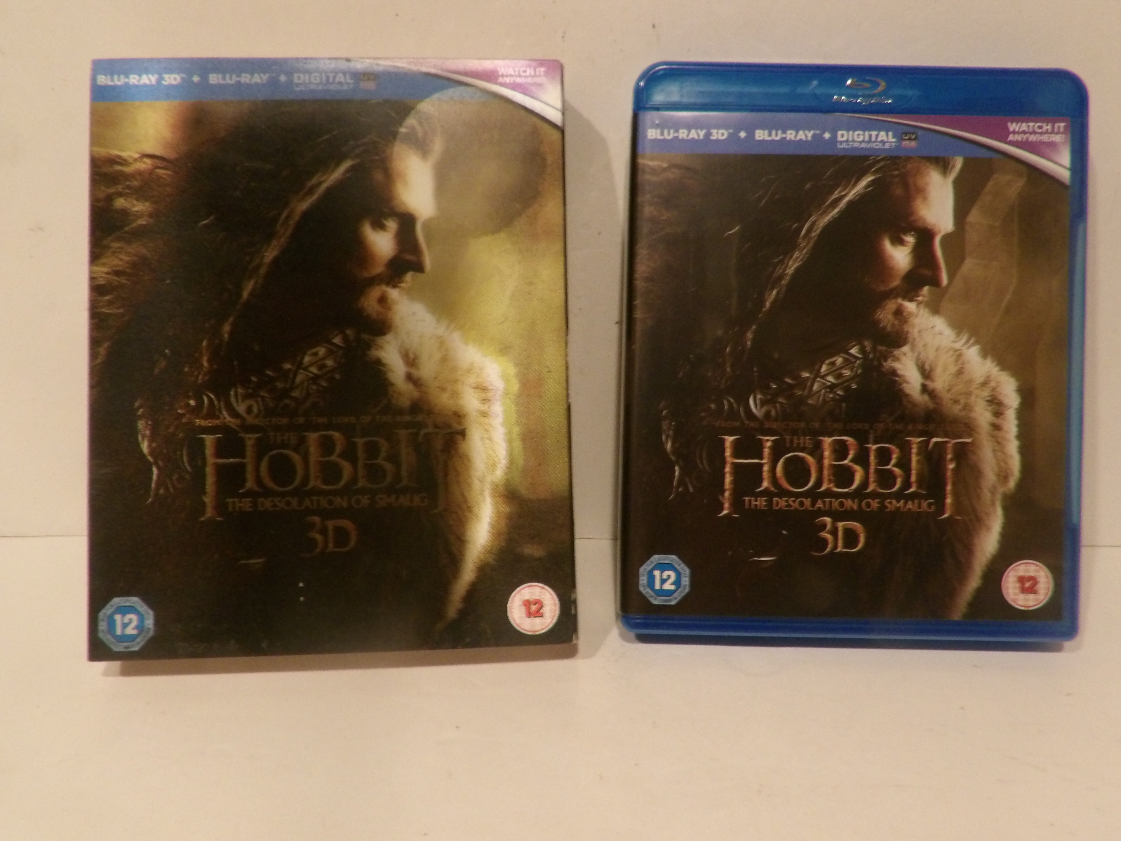 Two copies of The Hobbit: The Desolation of Smaug 3D Blu-ray and Blu-ray Disc set, one in a blue 3D case and one in a standard case, displayed side-by-side on a light surface.