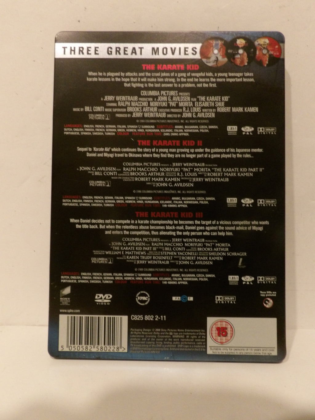 The back cover of a DVD box set for 'Three Great Movies' featuring the film 'The Karate Kid'. The packaging is black with white and red text, and includes a barcode and various DVD and studio logos at the bottom.
