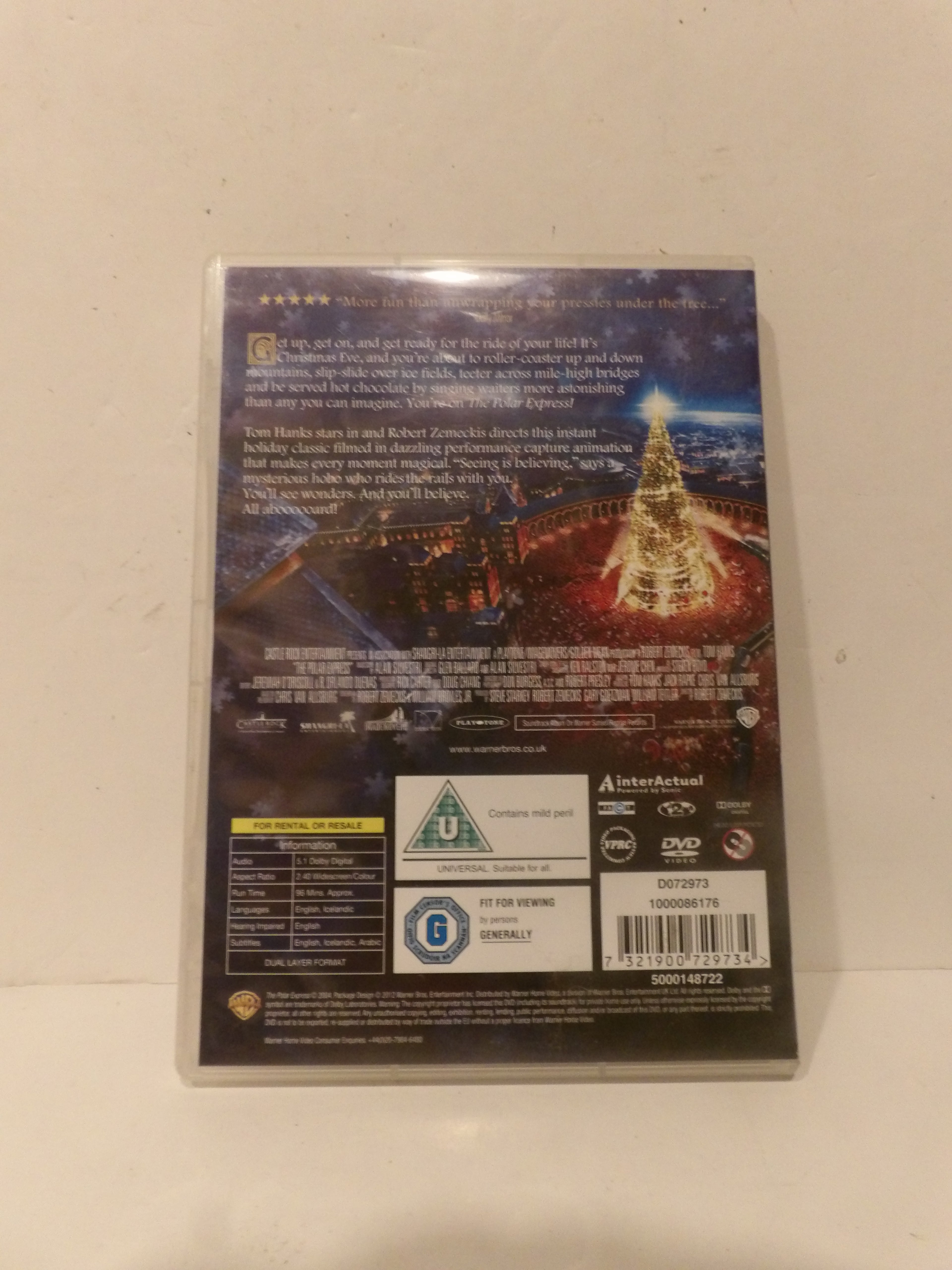 Back cover of a DVD case for the movie 'The Christmas Spirit', featuring a glowing Christmas tree scene, product text, and rating logos on a light beige background.