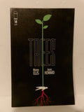 The front cover of the comic book Trees #14, featuring a black background with a stylized green sapling growing from a white bird, with red roots extending down. The title 'TREES' is written in large outlined letters, with creator names Warren Ellis and Jason Howard below.