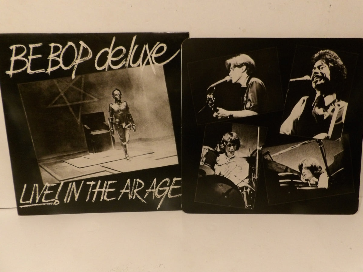 A BE BOP deluxe live album cover and a printed photo card featuring live performance photos of Jim Morrison, shown on a plain light background.